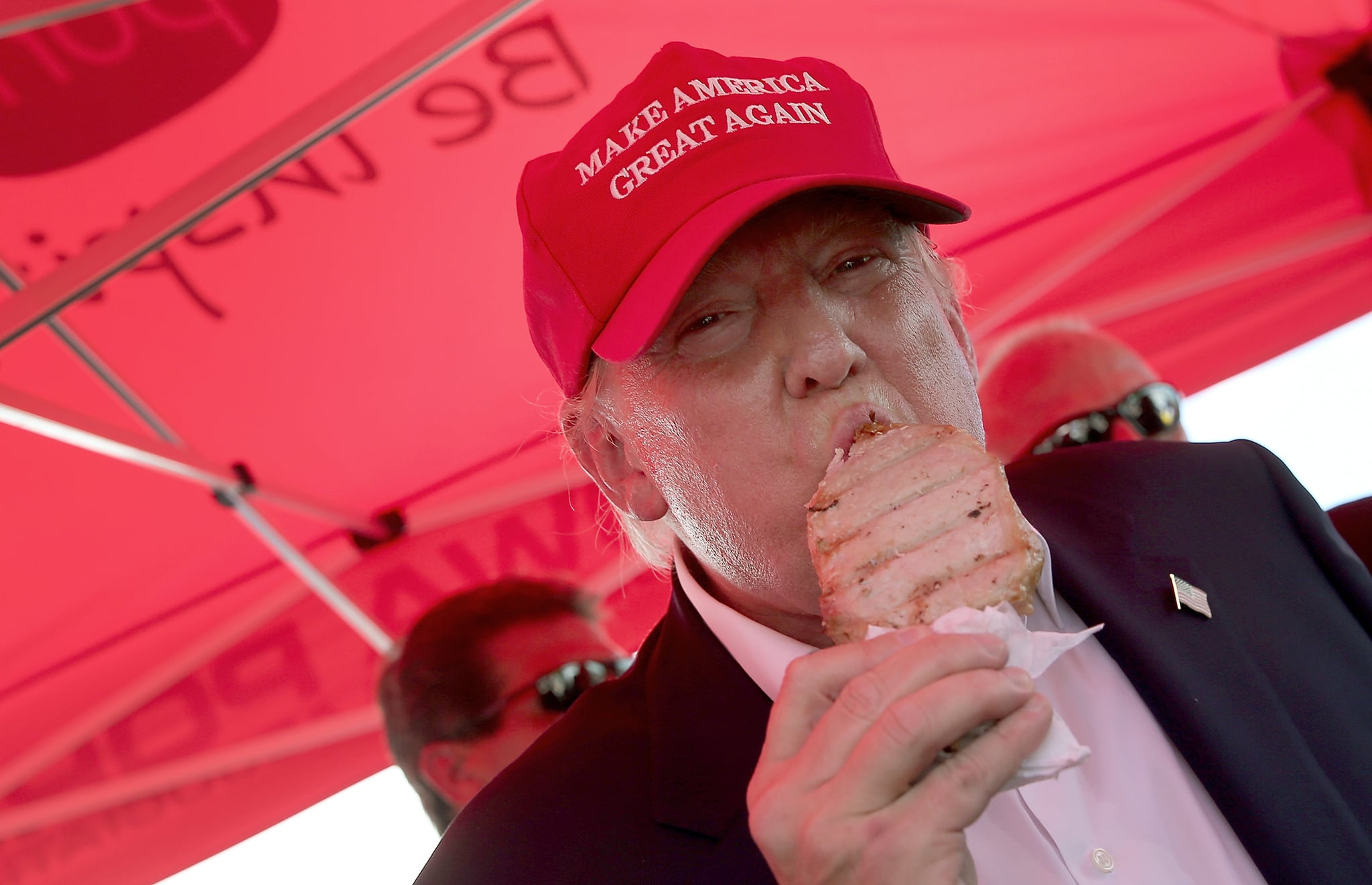 DES MOINES, IA - AUGUST 15:  Republican presidential candidate Donald Trump eats a pork chop on a stick and gives a thumbs up sign to fairgoers at the Iowa State Fair on August 15, 2015 in Des Moines, Iowa. Presidential candidates are addressing attendees at the Iowa State Fair on the Des Moines Register Presidential Soapbox stage and touring the fairgrounds. The State Fair runs through August 23.  (Photo by Win McNamee/Getty Images)