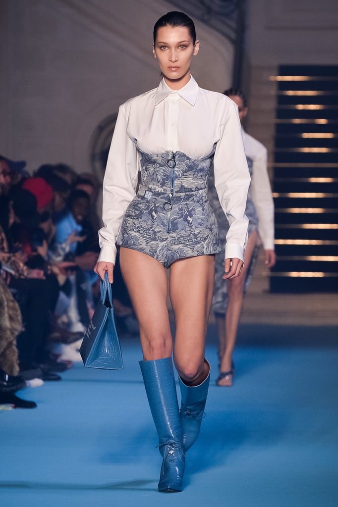 Walking in the Off-White show wearing a pair of bold blue boots.