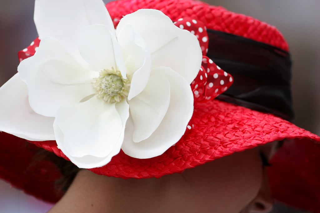 A woman wore a bright red hat with a big white flower to the 2011 race.