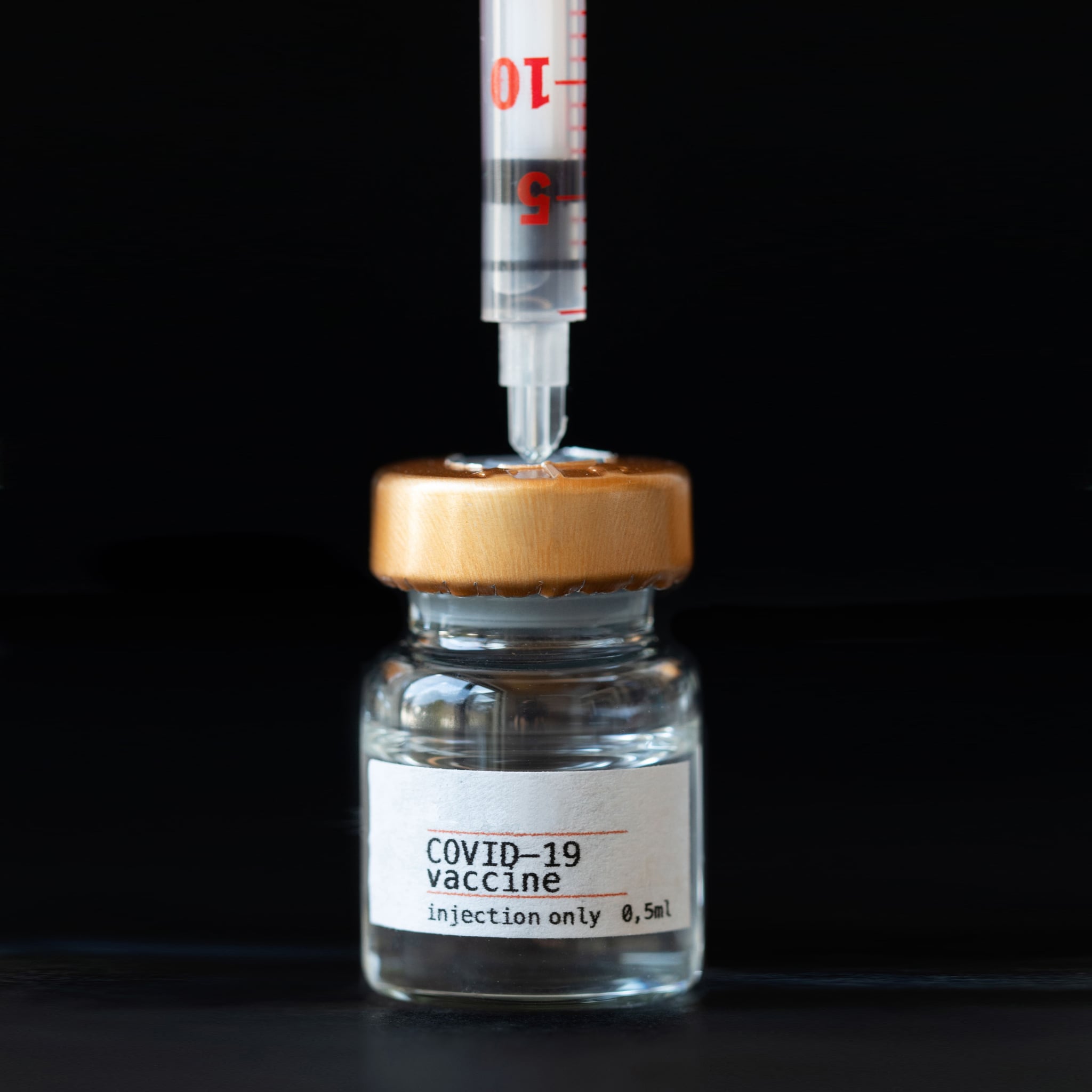 Coronavirus vaccine vial with AstraZeneca logo a black background.The concept of medicine, healthcare and science.