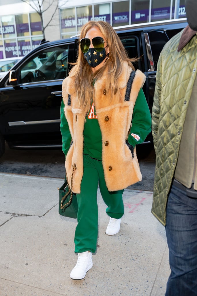 Styling a forest-green Mayfair Group sweatsuit with a fuzzy Coach vest on top.