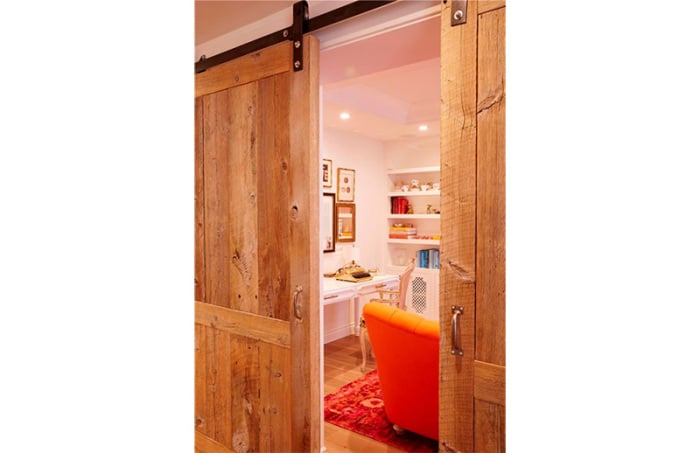 The master suite includes a lounge area separated with custom sliding reclaimed lumber doors.