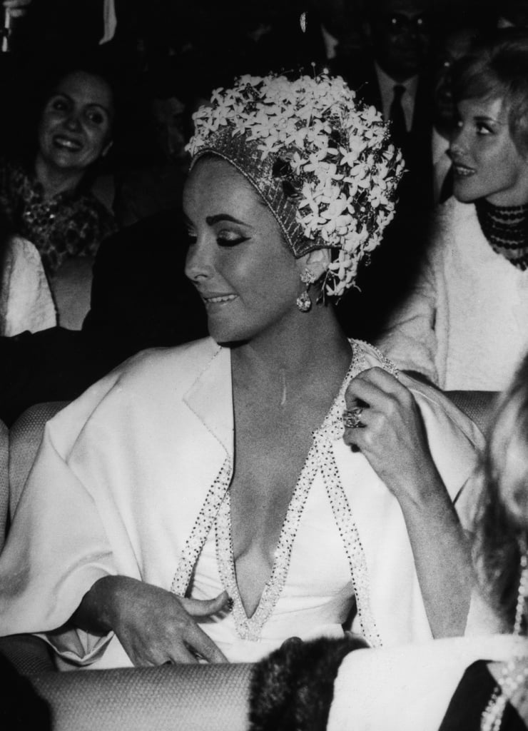 This gorgeous floral hat was matched with a low-cut dress and diamond earrings in 1961.