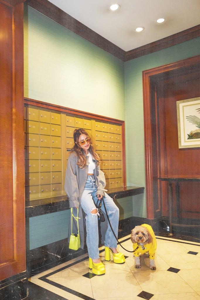 Amato walks her dog Tobi wearing the yellow Medusa Versace platforms ($1,575) with ripped jeans, a white cropped tee, gray trench coat, yellow acetate sunglasses, and Bottega Veneta's Cassette bag ($990) in kiwi.