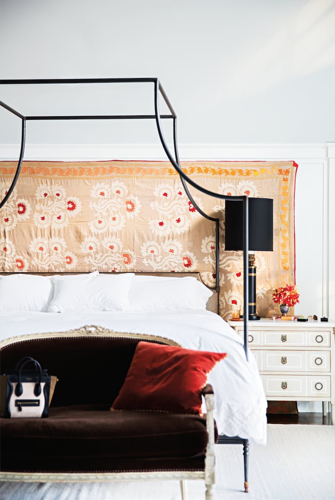 Forget wallpaper or paint — Katie created a dynamic accent wall behind her bed by hanging a large piece of fabric. For a similar effect, try hanging a lightweight rug or blanket. We love the way it looks with the canopy bed!