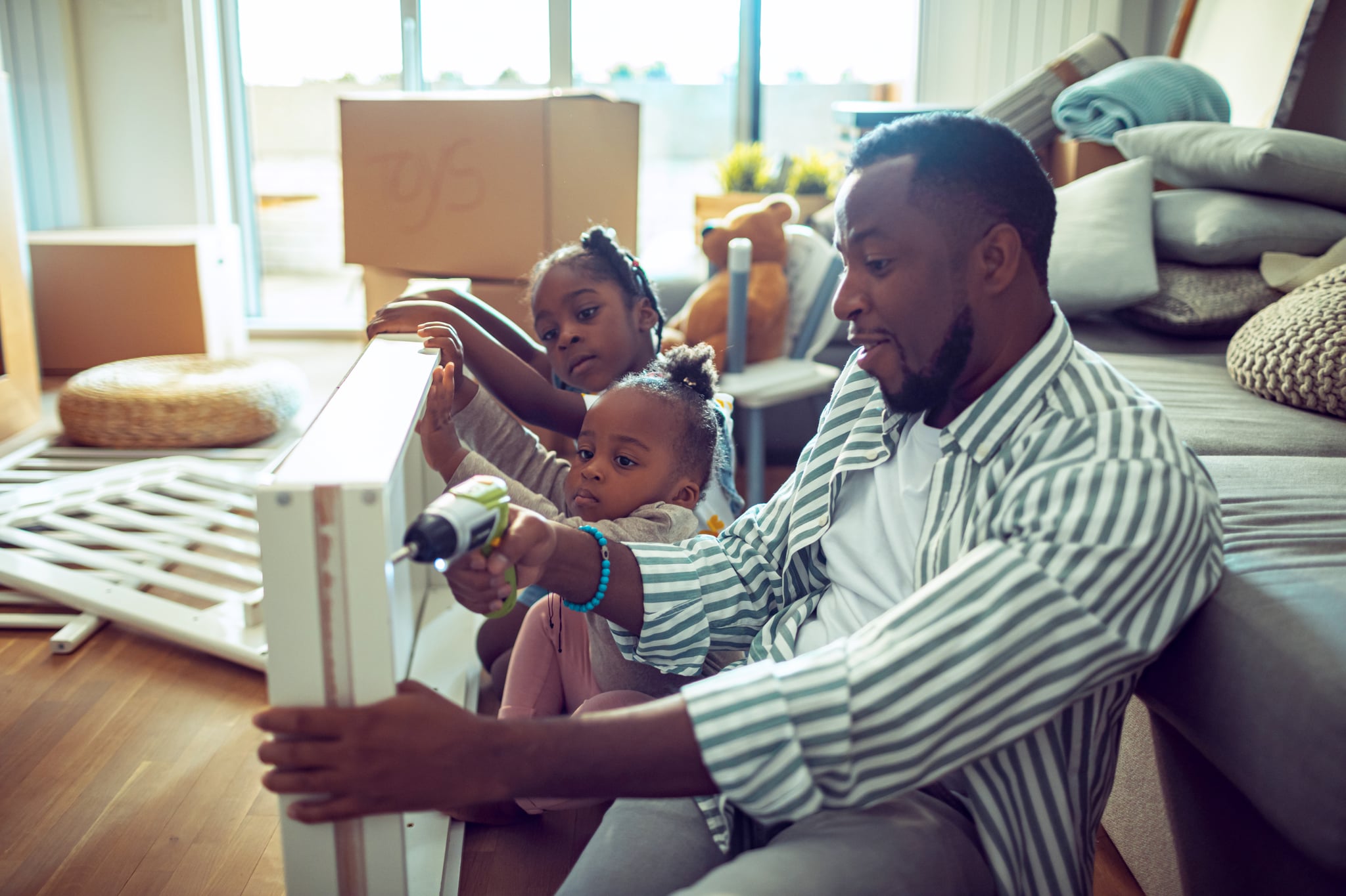 Close up of a young family making a crib in their new home