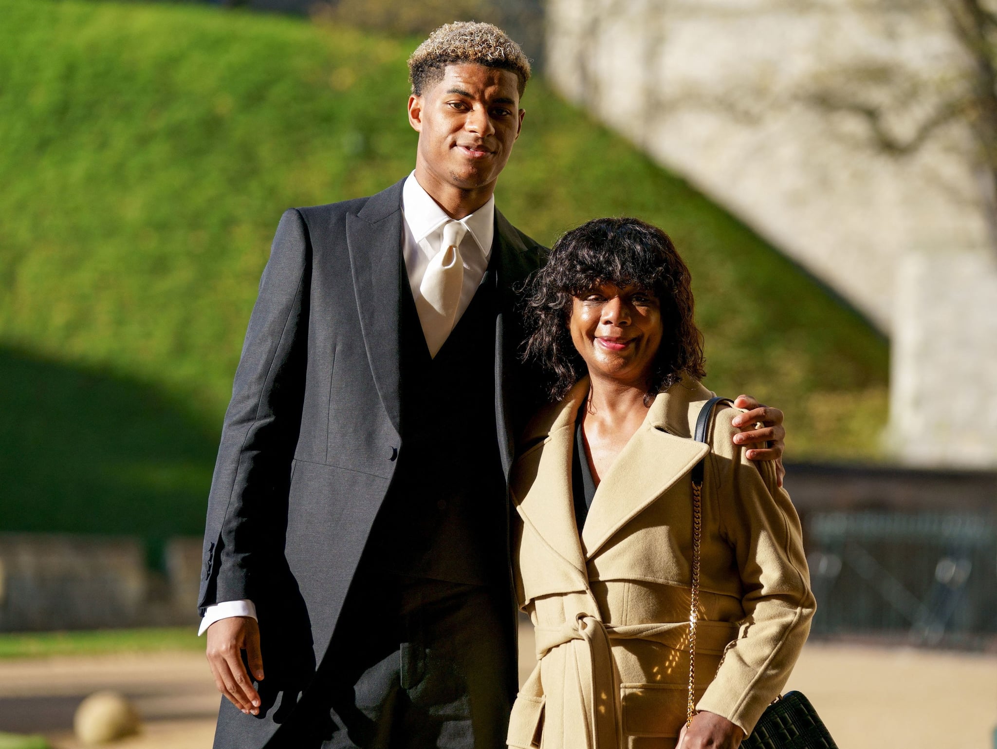 Manchester United and England footballer Marcus Rashford poses his mother Melanie Rashford before being appointed a Member of the Order of the British Empire (MBE) for services to Vulnerable Children in the UK during the Covid-19 pandemic, at an investiture ceremony at Windsor Castle in Windsor, west of London on November 9, 2021. (Photo by Andrew Matthews / POOL / AFP) (Photo by ANDREW MATTHEWS/POOL/AFP via Getty Images)