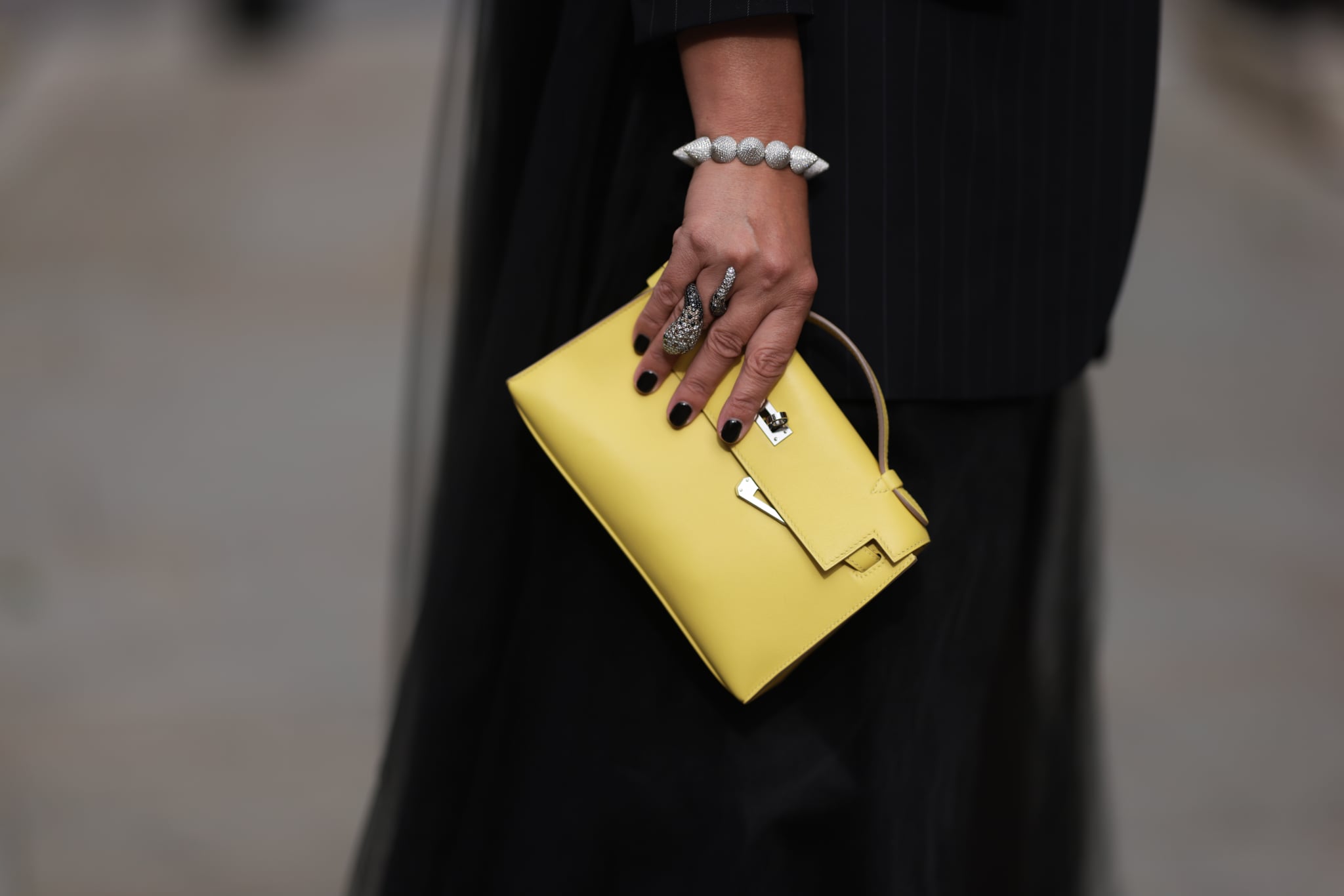 LONDON, ENGLAND - SEPTEMBER 17: Corina Mihaila Larpin is seen wearing bracelet and ring from Stéfère, a black pinstripe blazer with long tulle back from Monse and the Kelly bag from Hermès in yellow leather on September 17, 2023 in London, England. (Photo by Jeremy Moeller/Getty Images)