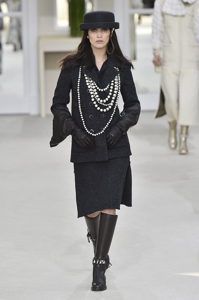 Bella looked like a modern-day Coco Chanel on the runway in her layers of pearls, crisp hat, and tailored separates. She finished her outfit with leather gloves and knee-high boots.