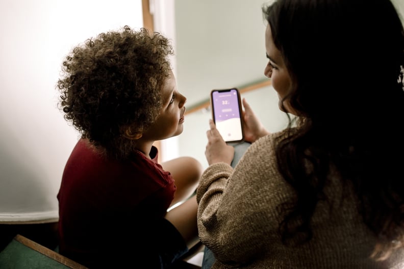 a mom holding a smartphone while talking to her child