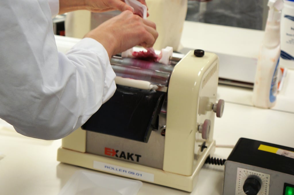 The wax base is gently scraped off the front and fed back into the roller, but this time small amounts of the pigment are poured in at the same time. You keep adding small amounts of pigment to the base as you feed it back into the roller. The whole process can take some time, as it's important to ensure the pigment is perfectly distributed throughout the base so the lipstick is uniform in colour.