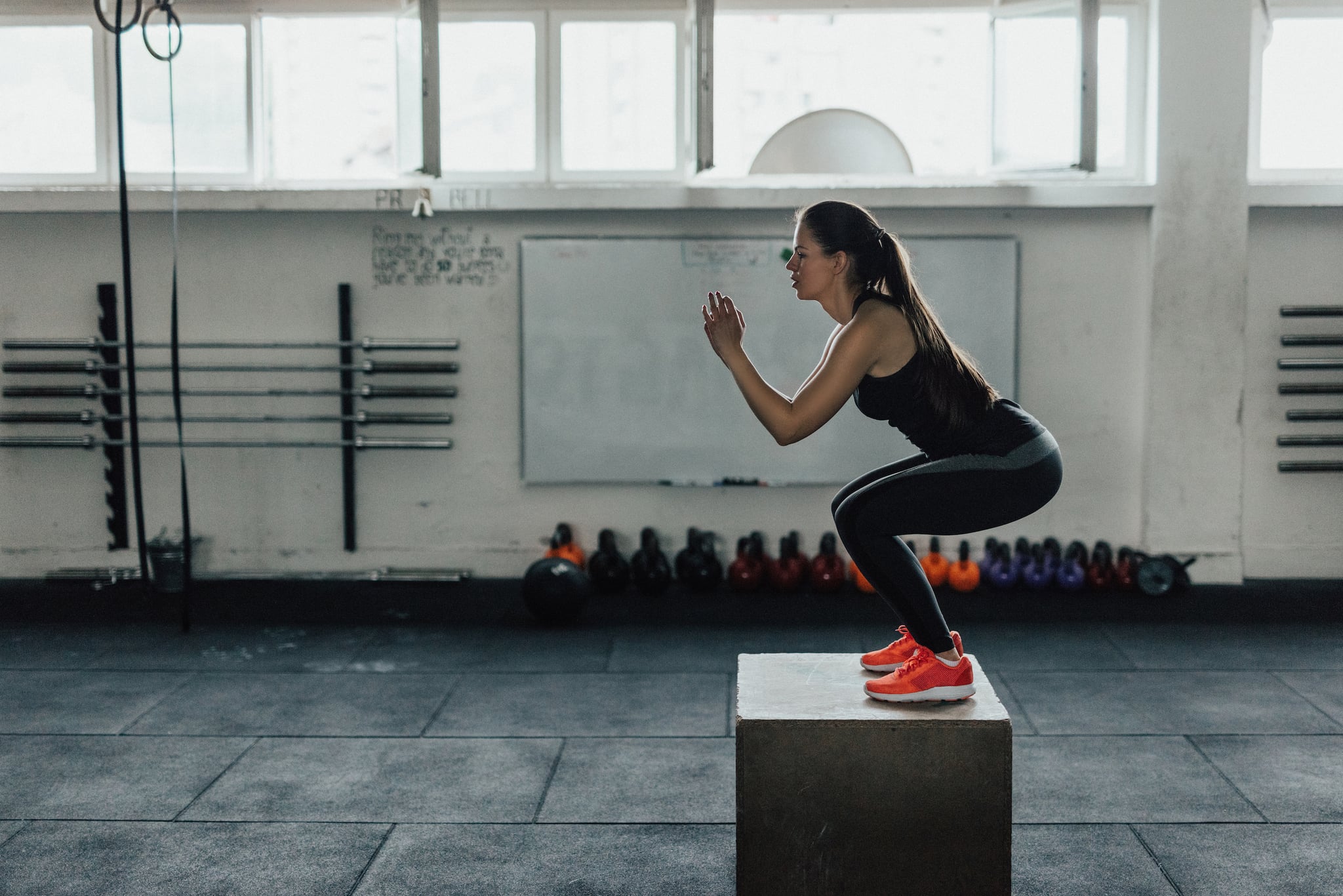 Beautiful woman doing box squats at the gym