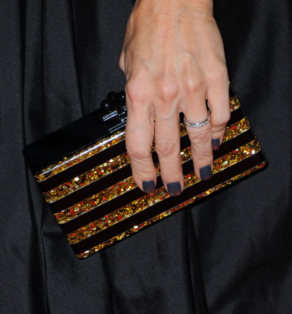 Monica Potter's striped Edie Parker clutch struck just the right note against her black and gold gown.