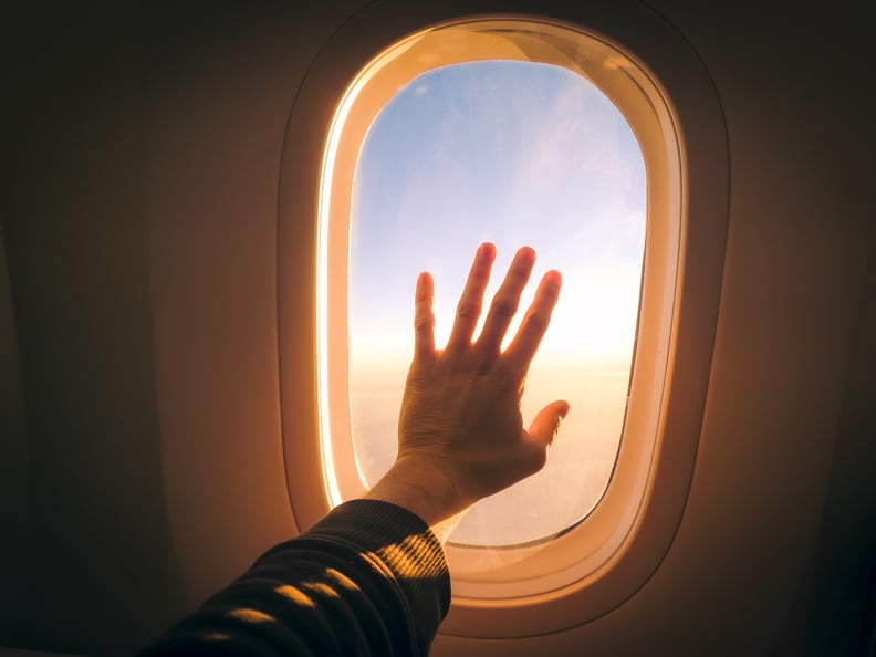 man's hand on an airplane window