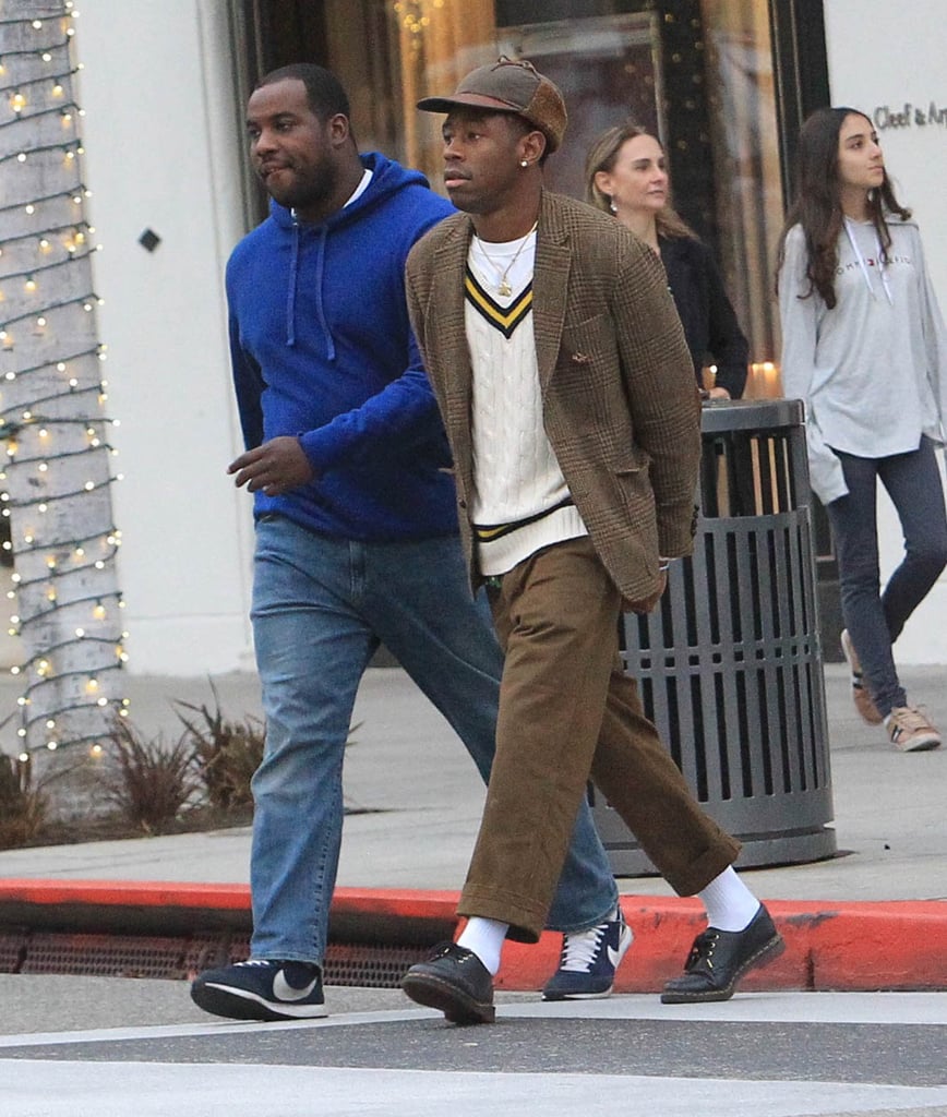 Tyler, the Creator looks relaxed in beige sweater vest and slacks