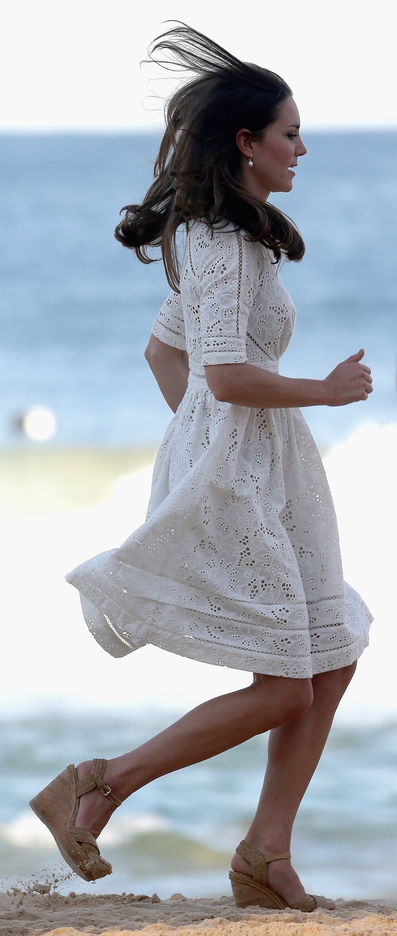 Kate running on the sand in wedges.