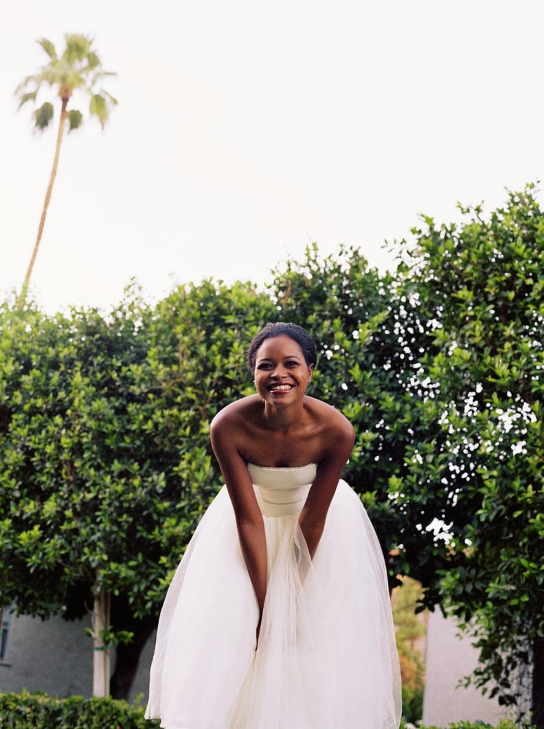 Young beautiful bride in underwear touching wedding dress. Bridal