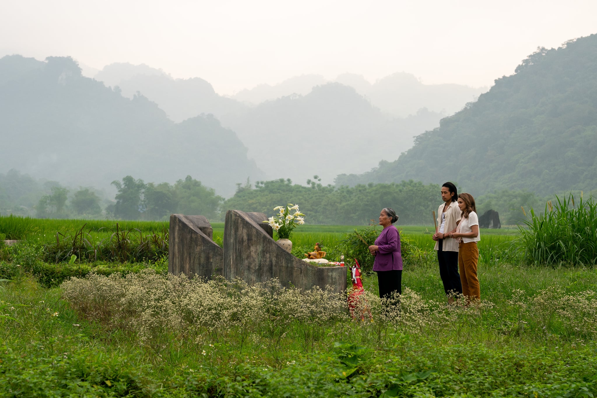 A Tourist's Guide to Love. (L to R) Le Thien as Ba Noi, Scott Ly as Sinh and Rachael Leigh Cook as Amanda in A Tourist's Guide to Love. Cr. Sasidis Sasisakulporn/Netflix  2022