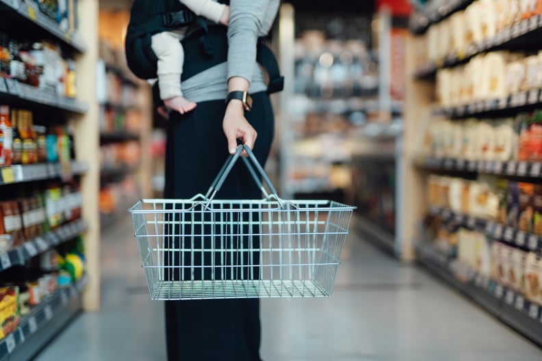 mom carrying baby and holding shopping basket