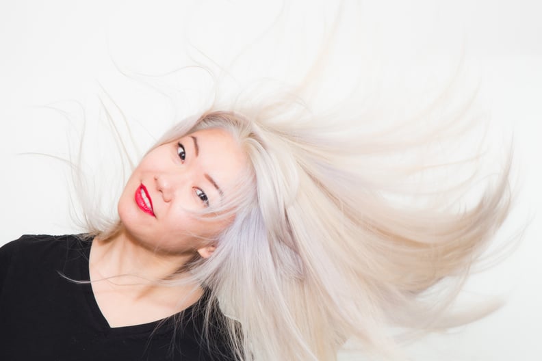 low angle view of attractive smiling blonde girl wearing white