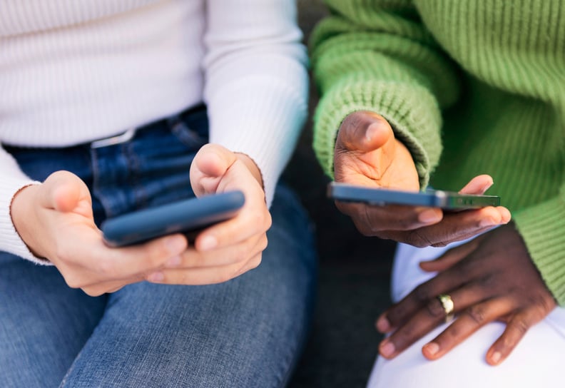 two friends holding phones in their hands