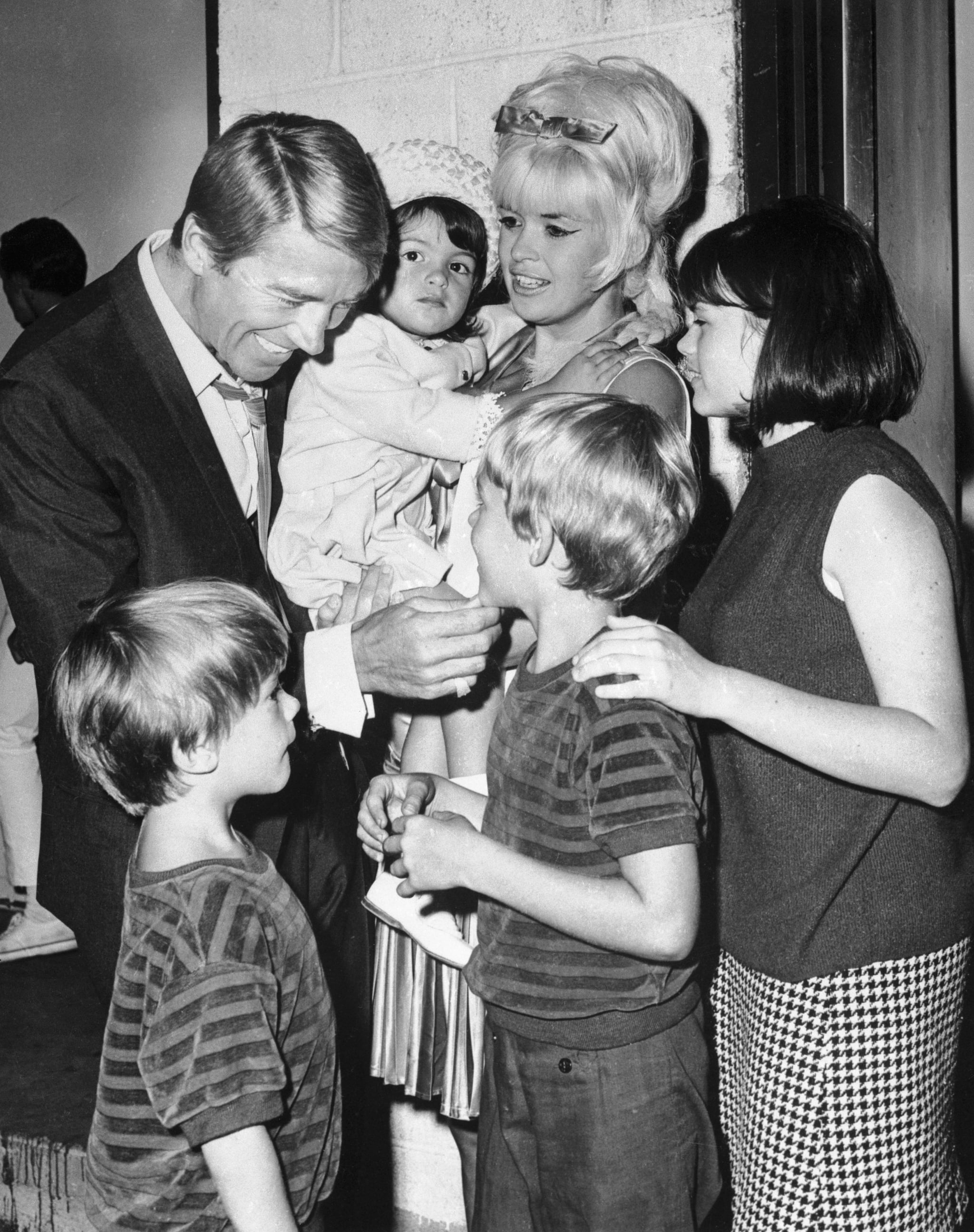 (Original Caption) Actor Mickey Hargitay is obviously enjoying his reunion with his former wife, actress Jayne Mansfield, and their children July 19th, backstage at the Westbury, L. I. Music Fair, where Miss Mansfield opened in Gentlemen Prefer Blondes. Hargitay flew in from Rome to be with his former wife, who was separated form her present husband, producer Matt Cimber, July 15th. The children are Zoltan, 5, Mikos, 7, and Mariska 2, and 14 year old Jayne Maria, Miss Mansfield's daughter by a previous marriage.