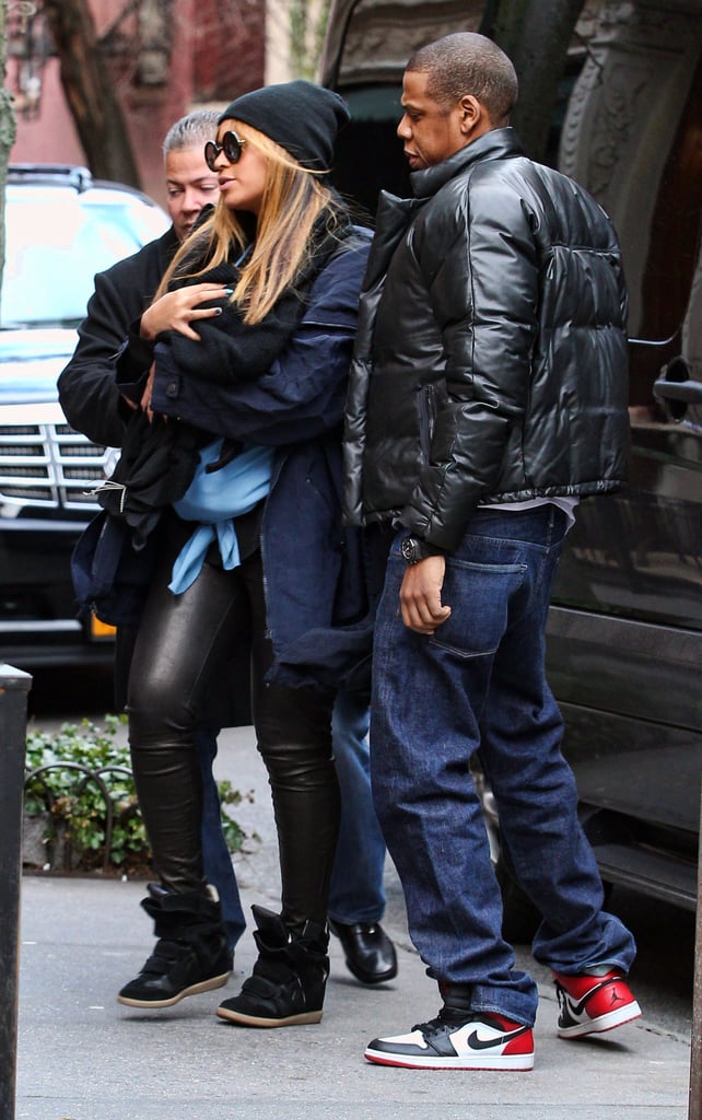 Beyoncé carried baby Blue Ivy in slick leather pants and a black beanie while JAY-Z followed behind in a stylish puffer jacket and Nikes in February 2012.