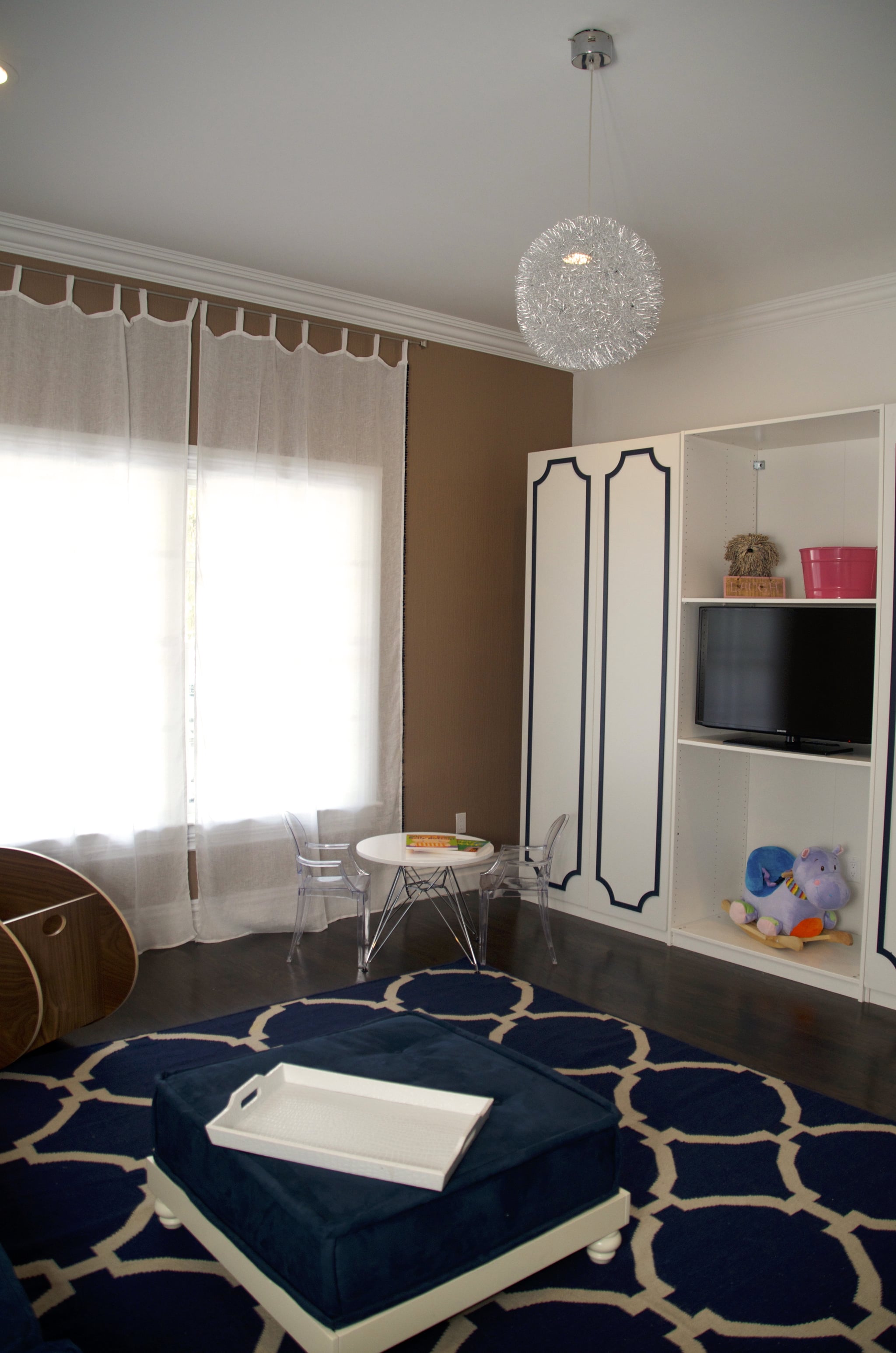 More of Vanessa's picks and resources: The pom-poms on the New Arrivals drapes are so sweet, but the linen is transparent to ensure lots of light gets into Alena's play space. I can't forget [to mention] the fact that the entire navy wall is chalkboard! I told them not to disclose this to Alena too early, but once she can distinguish which walls are OK to draw on, they can tell her. All of the paint is Lullaby Paints, which has no VOCS. The modern and funky light fixture and kids' table and chairs are by Zuo Modern. What's more fun than pint-sized ghost chairs?
Source: Vanessa Antonelli for Nessa Lee Baby
