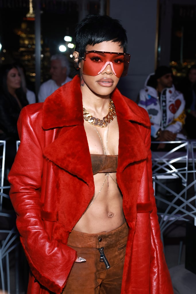 Teyana Taylor is making a splash at New York Fashion Week. The singer and actor was one of a handful of celebrities at LaQuan Smith's fall 2023 runway show on Feb. 13. Showcasing the expert tailoring and sexy silhouettes the designer is known for, Taylor paired a teeny-tiny suede bra top and matching low-rise cargo pants topped with a red floor-length overcoat. She accessorized with a delicate body chain draped over her chest, a gold chain necklace, and massive red shades covering half her face. 
Models showed Smith's latest collection at the opulent Rainbow Room in New York City, exhibiting '80s Hollywood glamour inspired by the original "Dynasty" television series. The line introduced structured suiting in patent blacks and metallic leathers, in addition to the brand's signature elements including extreme cutouts, sheer fabrics, and corset bodices. Taylor enjoyed the show from the front row alongside stars like Lil Nas X, Julia Fox, and Kimora Lee Simmons.
Earlier during NYFW, the mom of two celebrated Thom Browne's CFDA chairmanship in a full look by the designer, including a cropped cutout top and low-rise trousers in the brand's famous tartan print. Taylor and her entire family also recently wore coordinating khaki outfits by Browne for the premiere of "A Thousand and One" during the 2023 Sundance Film Festival.
Over the years, Taylor has certainly developed a go-to outfit formula, which often combines a low-rise bottom and ab-baring top, as displayed by her outfit at Smith's runway show. She similarly wore an ubercropped white tee and camo joggers that skimmed her hips while posing in the middle of a desert. 
See more photos of Taylor's recent style moment ahead. 

    Related:

            
            
                                    
                            

            Kate Spade Designers Talk Dressing Haley Lu Richardson and the Brand&apos;s New Direction