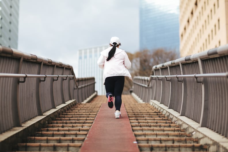 An overweight young Japanese woman is training in the city.