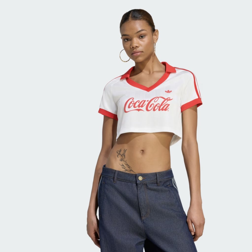 adidas x Coca-Cola Cropped Jersey ($50)
Gone are the days when sporty and stylish were considered mutually exclusive. This cropped top is a chic and flirty way to dress for the World Cup, and can be paired easily with wide leg jeans or a pleated tennis skirt. Our recommendation? Style it with the adidas x Coca-Cola Firebird Track Pant ($100) for a look that's as festive as it is chic.